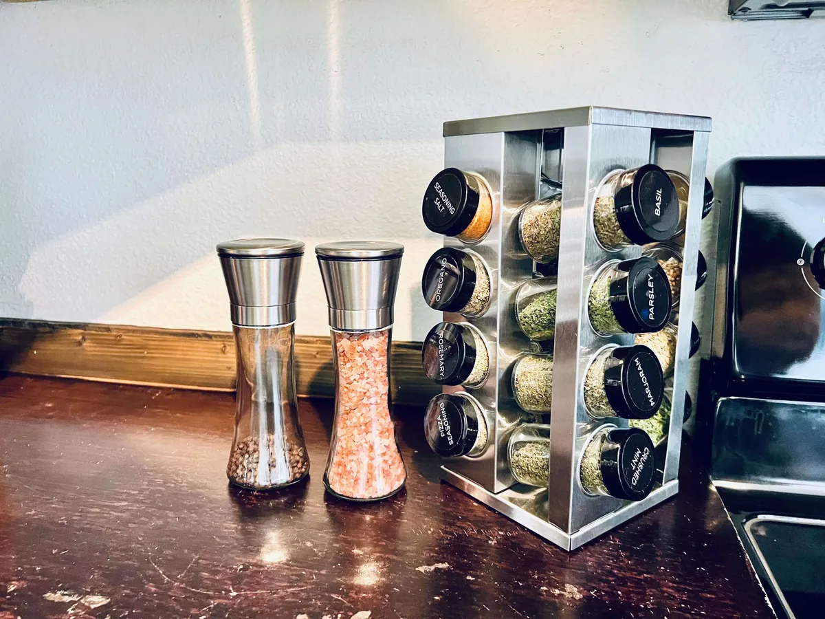 A close-up of salt and pepper shakers and a well-stocked spice rack, emphasizing the kitchen's readiness for cooking and creativity. The shot feels homey and practical, inviting guests to imagine preparing delicious meals.